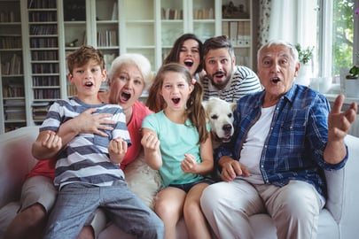 Happy family watching television in living room at home