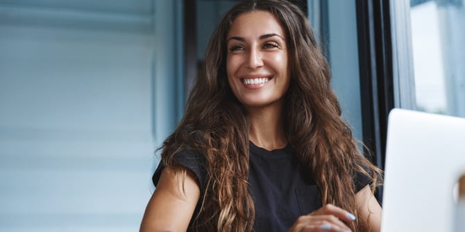 woman-sitting-at-her-computer-smiling